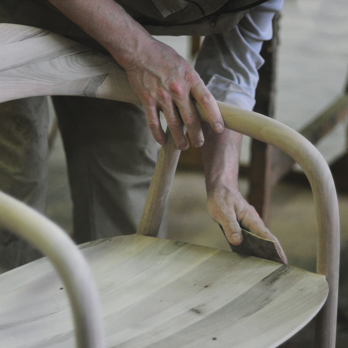 Sandpapering wooden chair